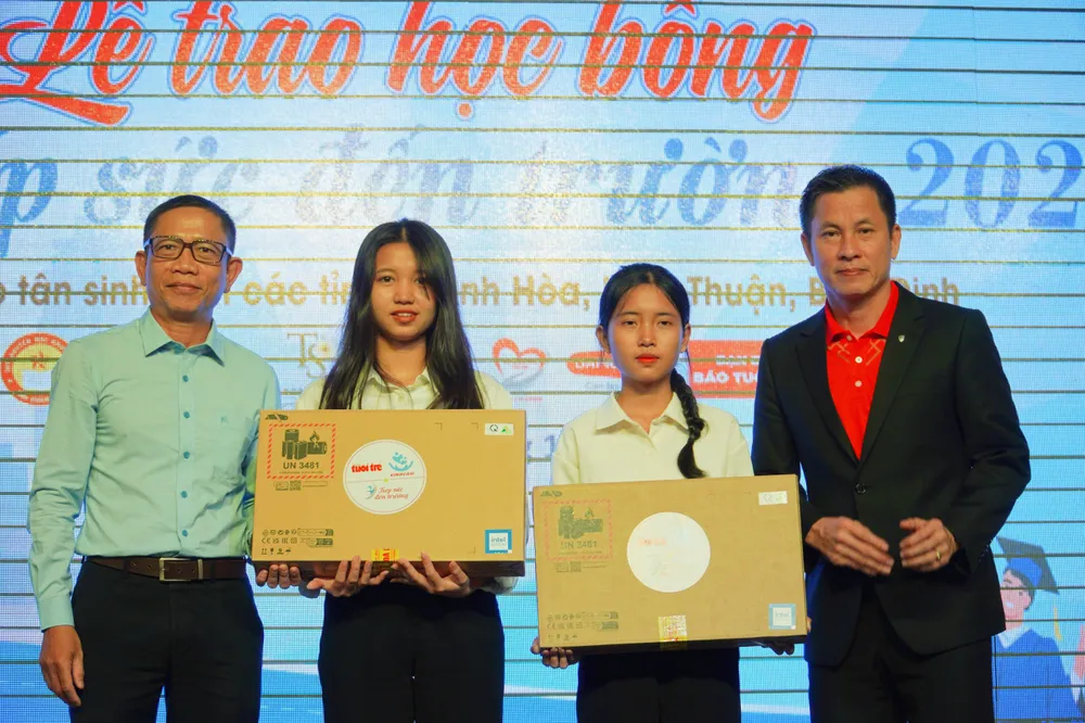 Đại diện báo Tuổi Trẻ trao máy tính cho tân sinh viên. Ảnh: DUYÊN PHAN học bổng.jpg
